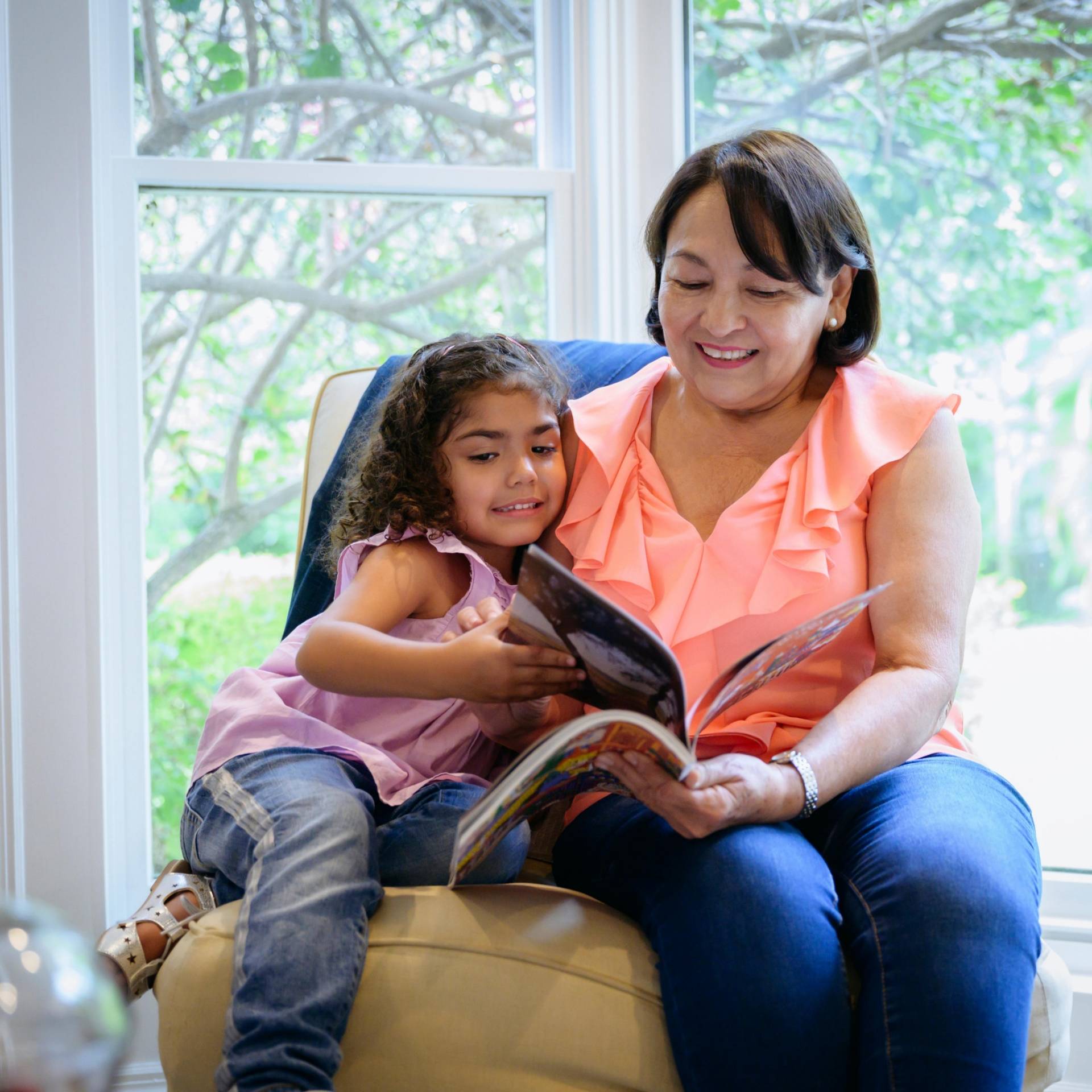 Grandmother reading a book to her young granddaughter